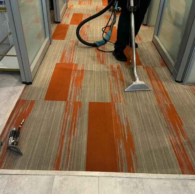 Cleaner using a carpet extractor on office carpet