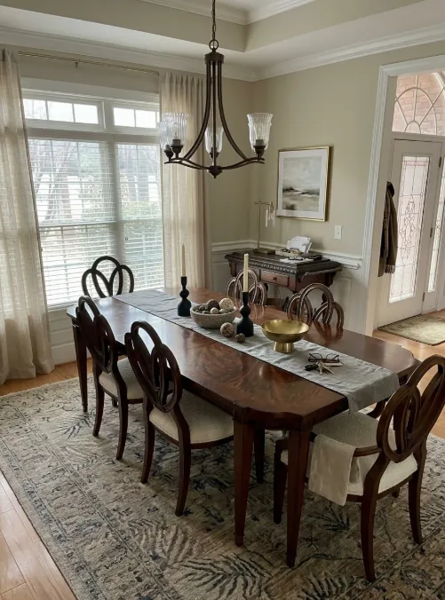 Dining room with a wood table, chairs, and an area rug