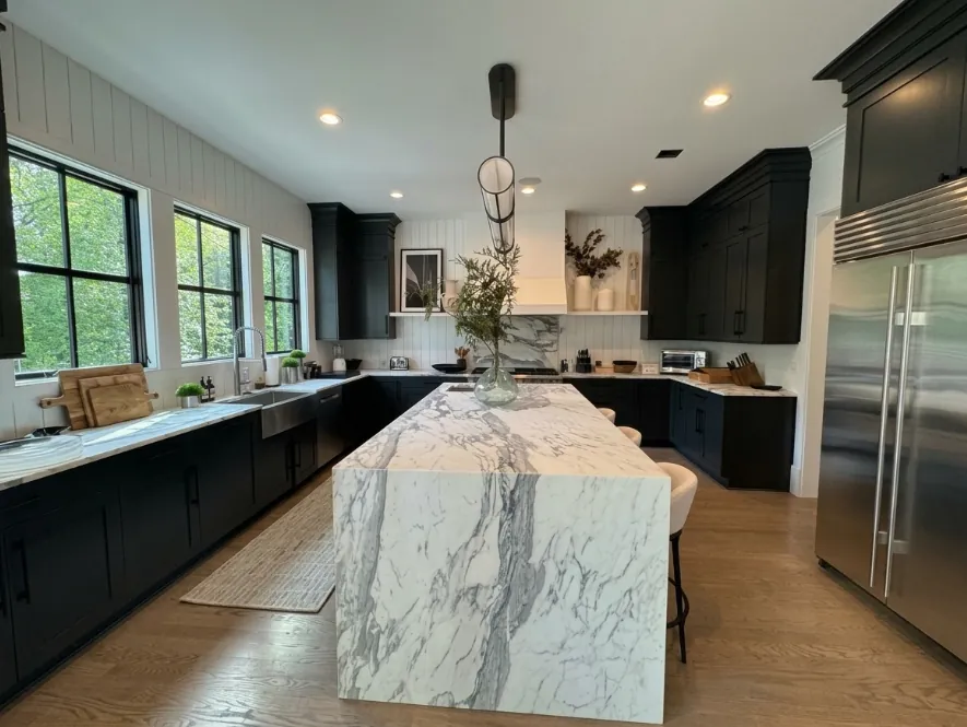 Kitchen with dark cabinets and a white marble waterfall island